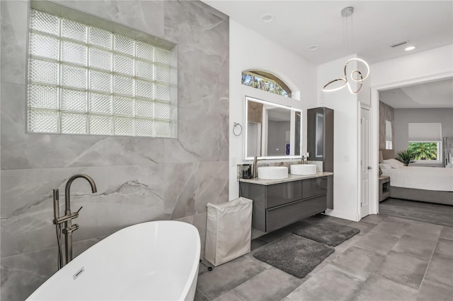 bathroom with vanity, a bathing tub, and tile walls