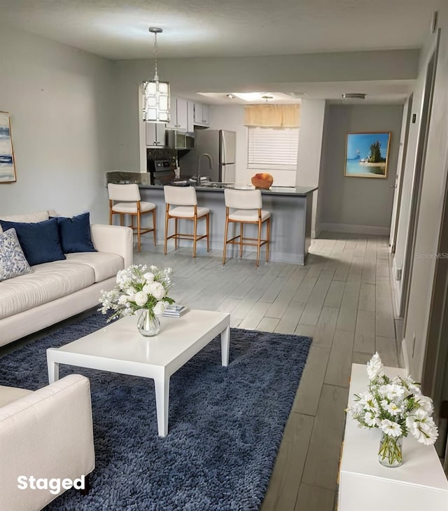 living room with baseboards and light wood finished floors