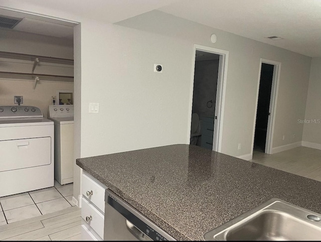 kitchen with washer and clothes dryer, dark countertops, visible vents, white cabinets, and dishwasher