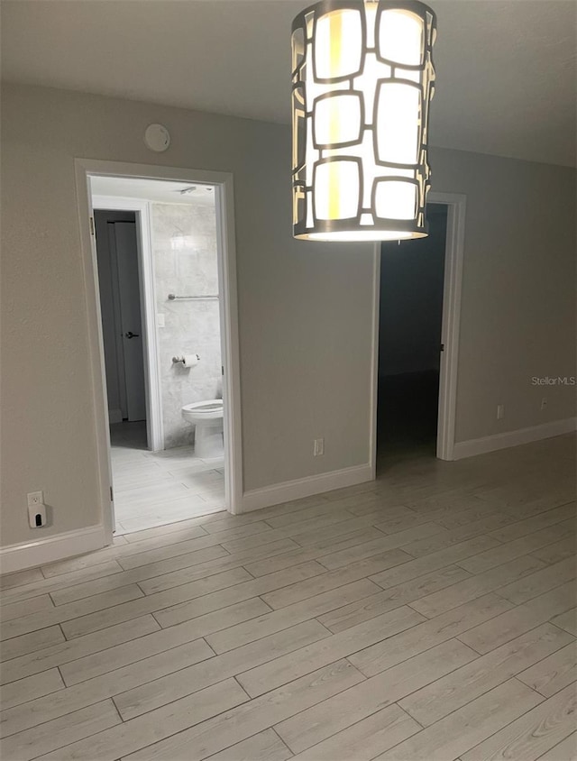 unfurnished dining area featuring baseboards and light wood-style floors