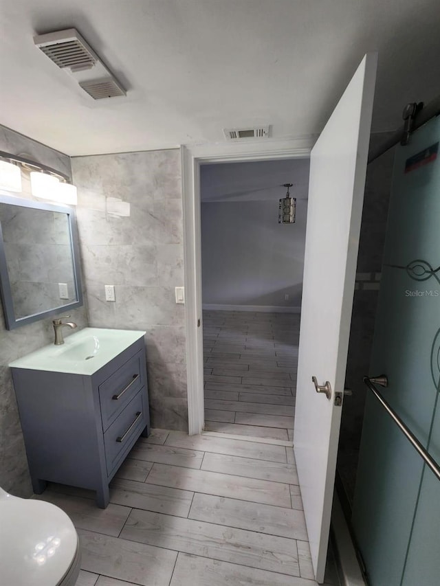 1804 University Ln Unit 308, Cocoa, FL 32922 - bathroom featuring vanity, toilet, tile walls, and wood tiled floors