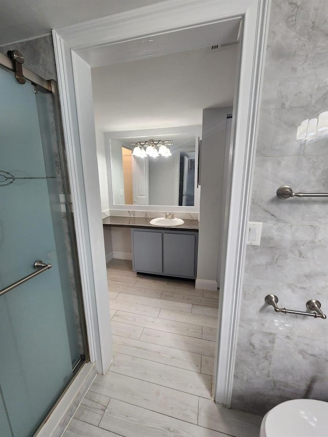 1804 University Ln Unit 308, Cocoa, FL 32922 - full bathroom featuring vanity, a stall shower, toilet, and wood finished floors
