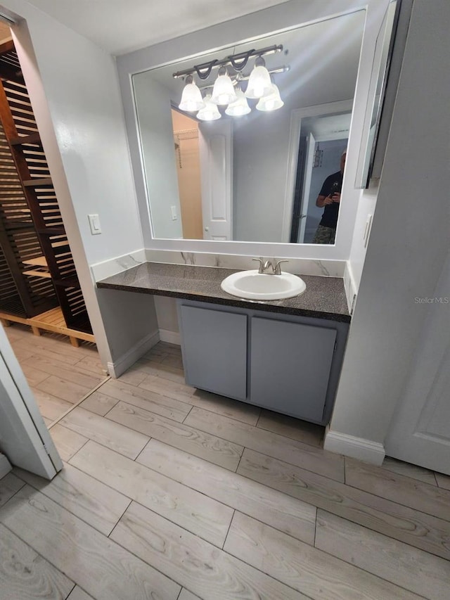 1804 University Ln Unit 308, Cocoa, FL 32922 - bathroom with wood finish floors, vanity, baseboards, and a chandelier