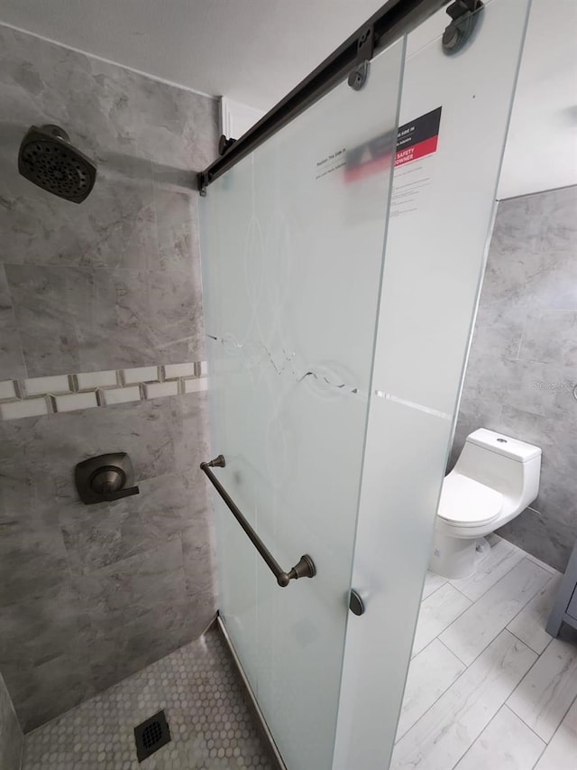 1804 University Ln Unit 308, Cocoa, FL 32922 - bathroom with a shower stall, tile walls, and toilet