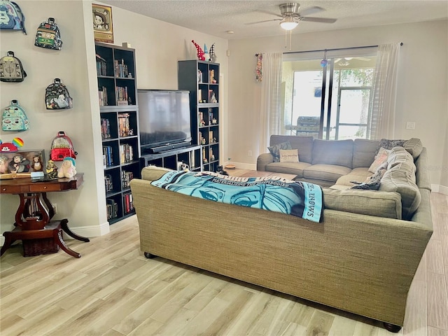 living room featuring ceiling fan, hardwood / wood-style floors, and a textured ceiling