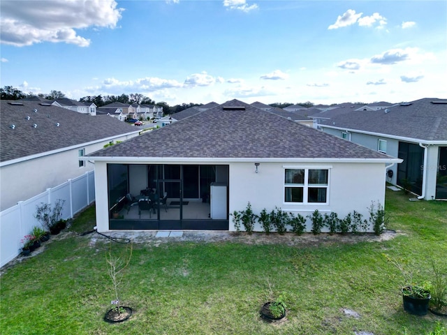 rear view of property featuring a sunroom and a yard