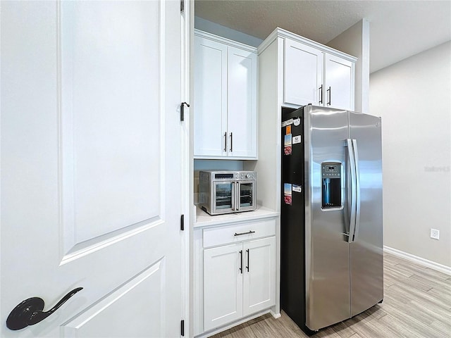 kitchen featuring white cabinets, light hardwood / wood-style floors, and stainless steel fridge with ice dispenser