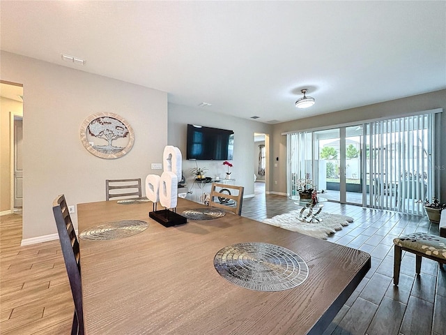 dining area with hardwood / wood-style flooring and french doors