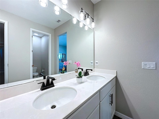 bathroom featuring vanity and toilet