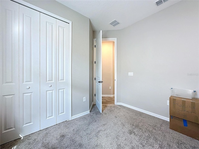 unfurnished bedroom with a closet, a textured ceiling, and carpet flooring