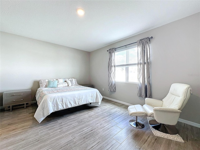 bedroom featuring a textured ceiling and light wood-type flooring