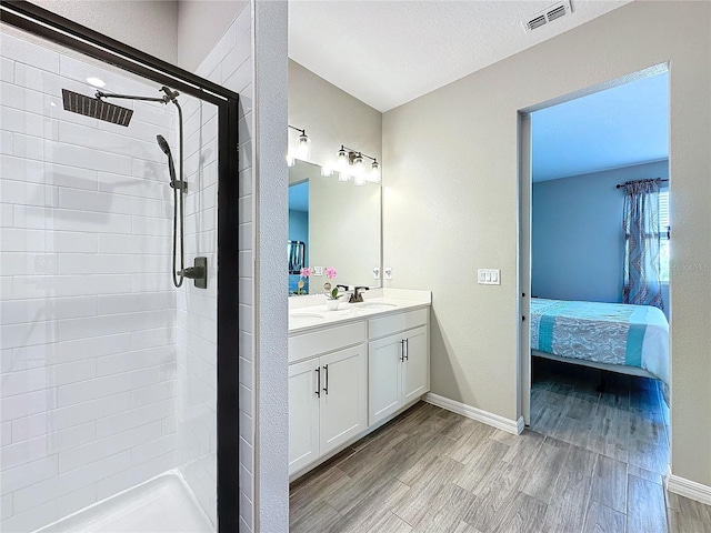 bathroom with vanity, hardwood / wood-style floors, and a tile shower