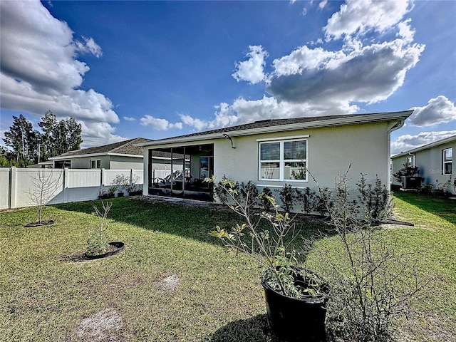 rear view of house featuring a lawn