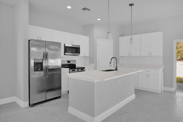 kitchen featuring appliances with stainless steel finishes, decorative light fixtures, white cabinetry, sink, and a kitchen island with sink