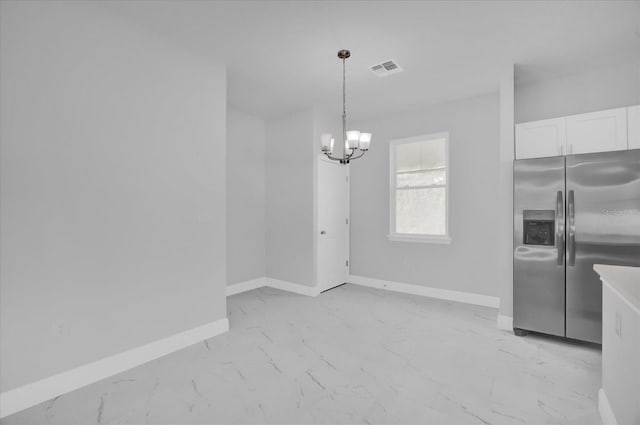 unfurnished dining area with a chandelier