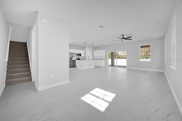 unfurnished living room with ceiling fan