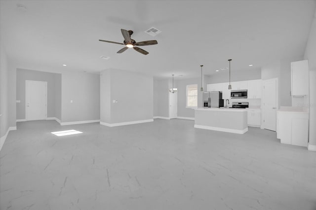 unfurnished living room featuring sink and ceiling fan with notable chandelier