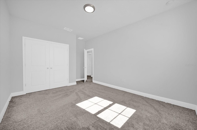 unfurnished bedroom featuring carpet floors and a closet