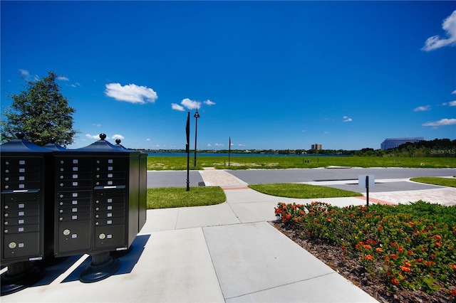 surrounding community with a water view and mail boxes