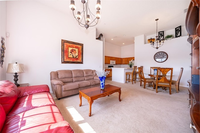 living room with a high ceiling, light carpet, and a notable chandelier