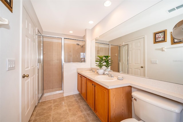 bathroom with vanity, tile patterned flooring, a shower with door, and toilet