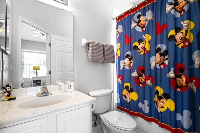 bathroom featuring ceiling fan, vanity, a shower with shower curtain, and toilet