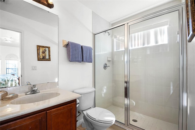 bathroom with toilet, a shower with shower door, and vanity