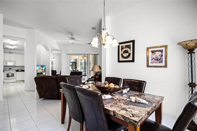 tiled dining area featuring ceiling fan with notable chandelier