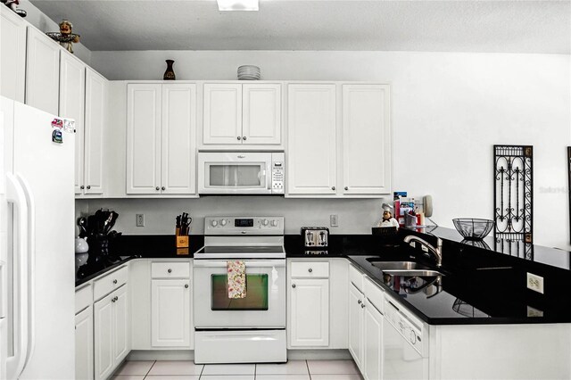 kitchen featuring white appliances, light tile patterned floors, sink, and white cabinets