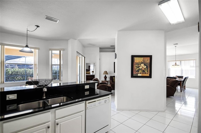 kitchen featuring white dishwasher, white cabinets, pendant lighting, light tile patterned floors, and sink