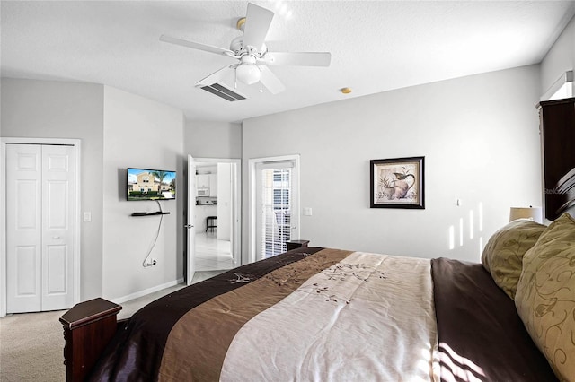 bedroom featuring a textured ceiling, light carpet, and ceiling fan