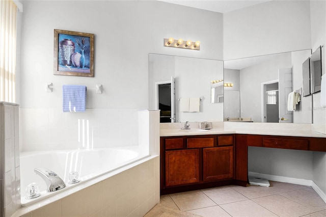 bathroom with vanity, a relaxing tiled tub, and tile patterned floors