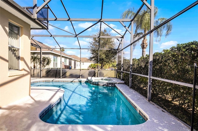 view of swimming pool with an in ground hot tub and a lanai