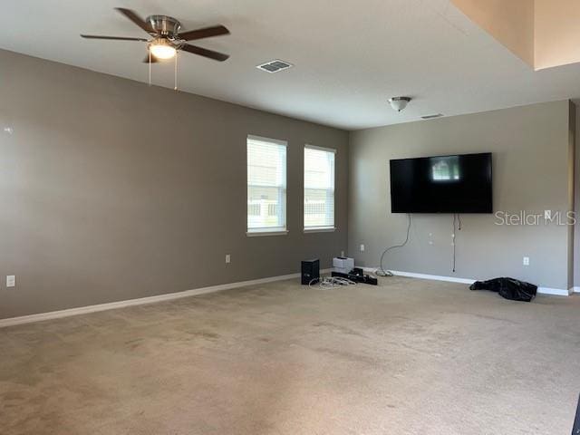 unfurnished living room with visible vents, baseboards, a ceiling fan, and carpet flooring