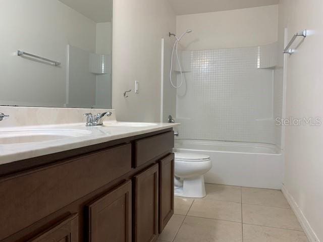 bathroom featuring toilet, double vanity, tile patterned floors, washtub / shower combination, and a sink