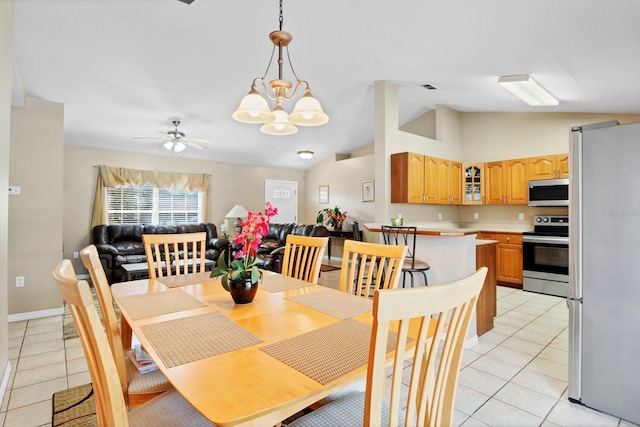 tiled dining space featuring vaulted ceiling and ceiling fan with notable chandelier