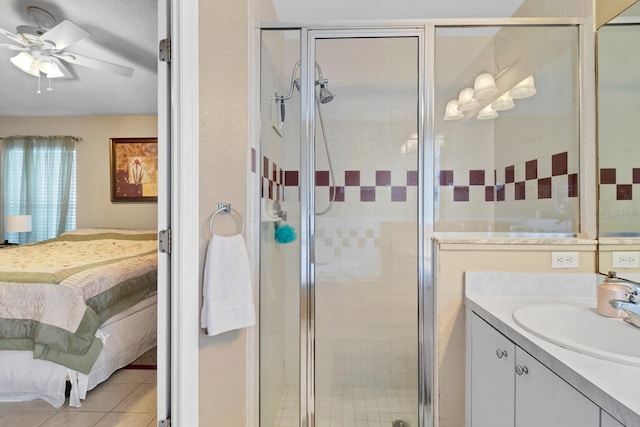 bathroom with ceiling fan, vanity, tile patterned flooring, and a shower with door