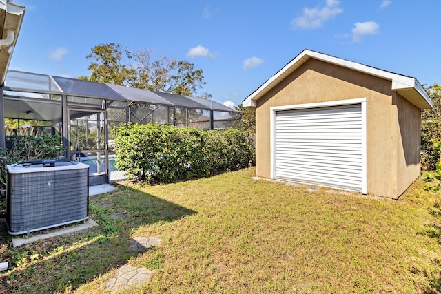 view of yard with a lanai, central AC unit, and a swimming pool