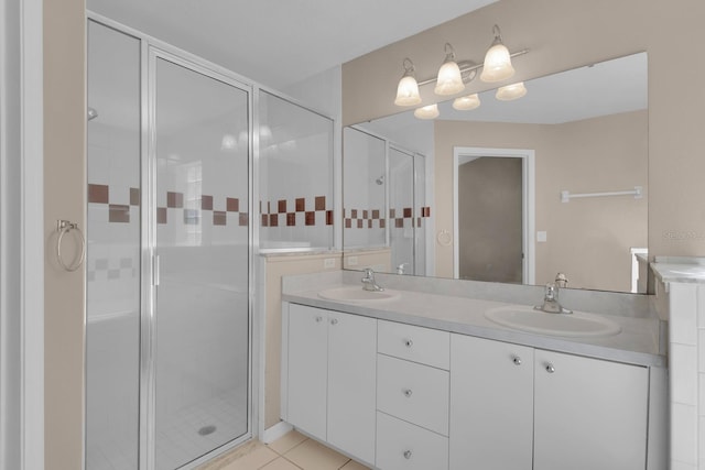 bathroom featuring a stall shower, double vanity, and a sink