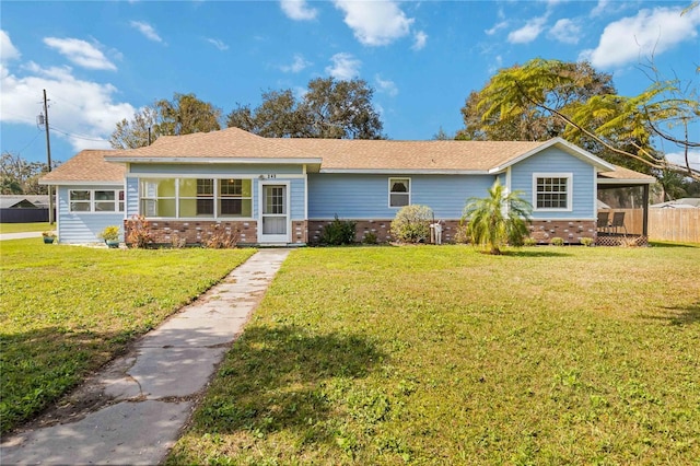 ranch-style house featuring a sunroom and a front yard