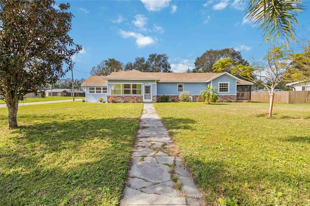 ranch-style home featuring a sunroom and a front yard