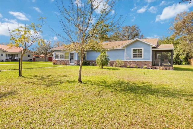 view of front of house featuring a sunroom and a front yard