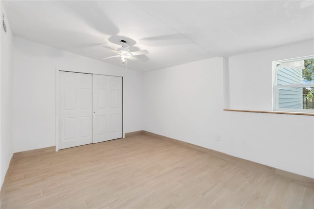 unfurnished bedroom featuring light hardwood / wood-style flooring, a closet, and ceiling fan