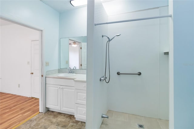 bathroom featuring walk in shower and vanity