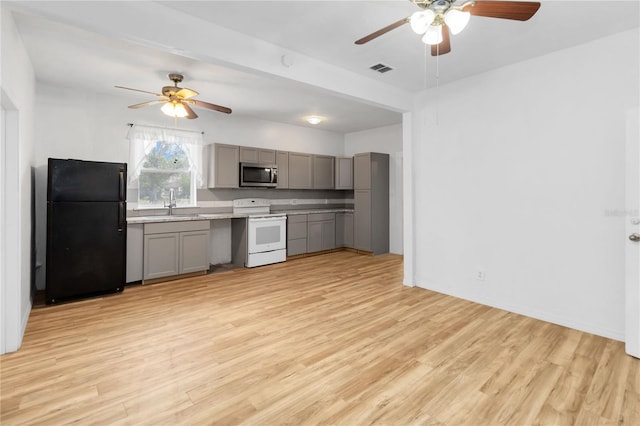 kitchen featuring black refrigerator, gray cabinetry, light hardwood / wood-style flooring, and white range with electric stovetop