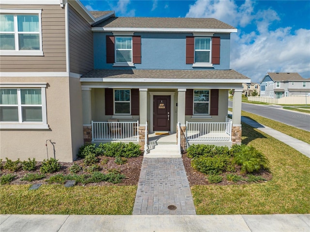 view of front of house with a shingled roof and stucco siding