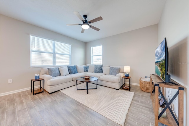 living room featuring wood tiled floor, baseboards, and ceiling fan