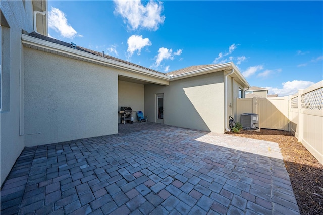 view of patio with a fenced backyard, a gate, cooling unit, and area for grilling