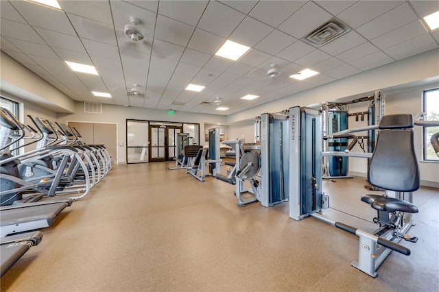 gym with a paneled ceiling and visible vents