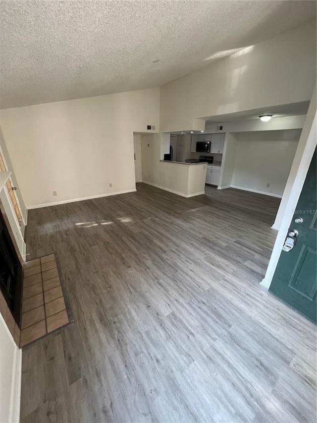 unfurnished living room featuring dark hardwood / wood-style floors and a textured ceiling